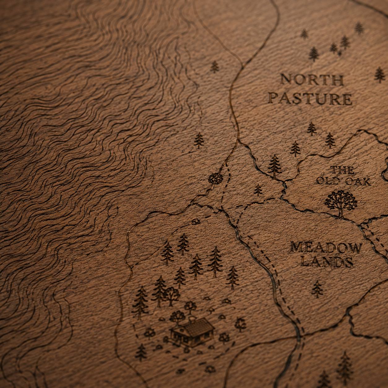 Framed etched wooden property map of a Montana ranch with contours and named pastures