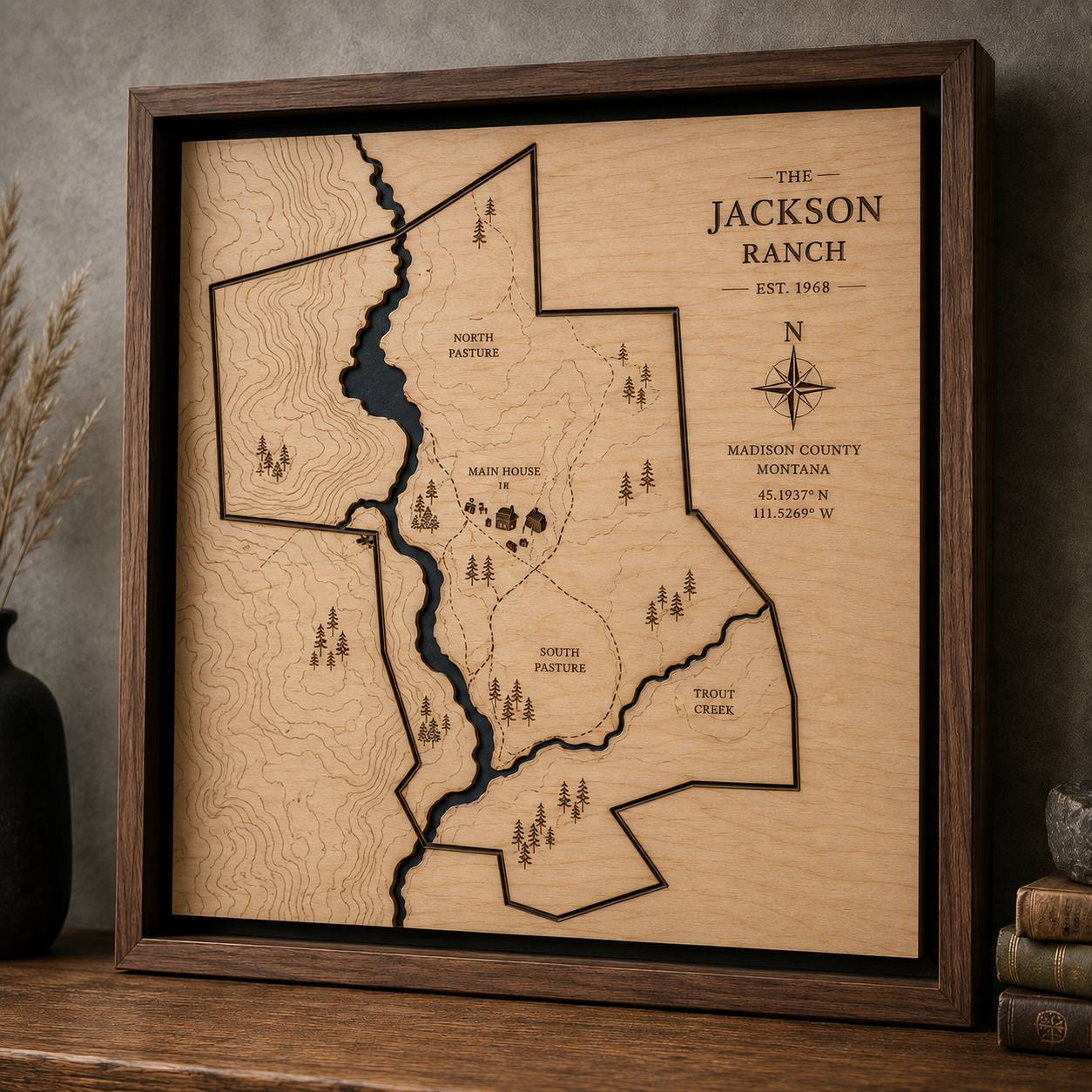 Framed etched wooden property map of a ranch, with land contours and named pastures